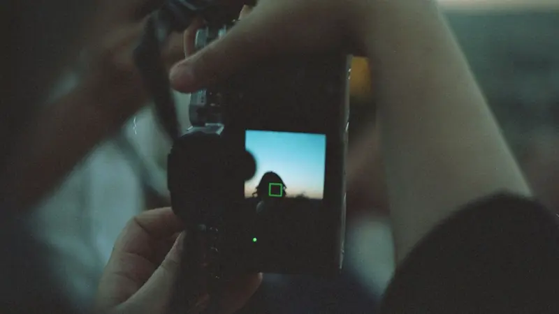 A photographer framing a shot through a camera viewfinder