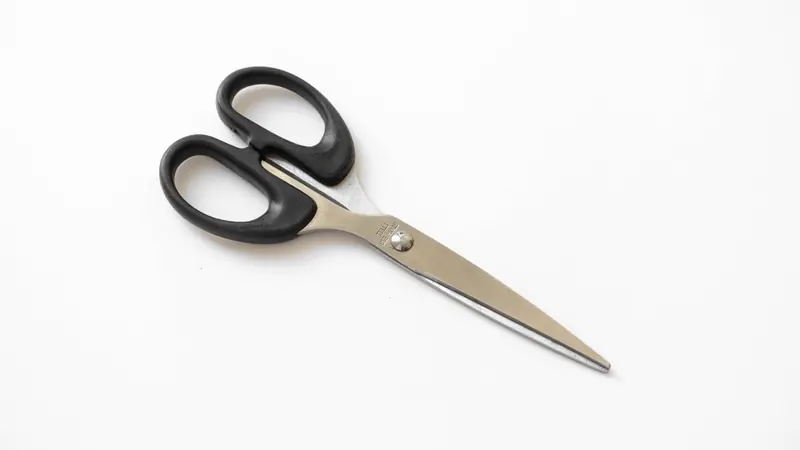 Scissors trimming a sheet of paper
