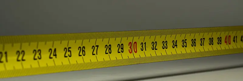 A steel tape measure extended across a workbench