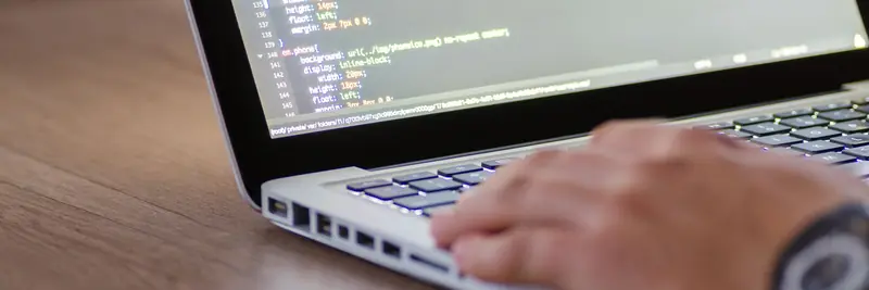 A developer reading code on a laptop screen