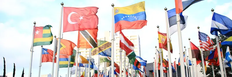 International flags flying side by side against a clear sky