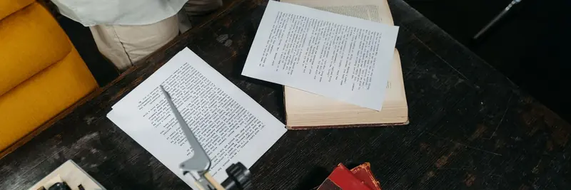 Typed manuscript pages beside a vintage typewriter