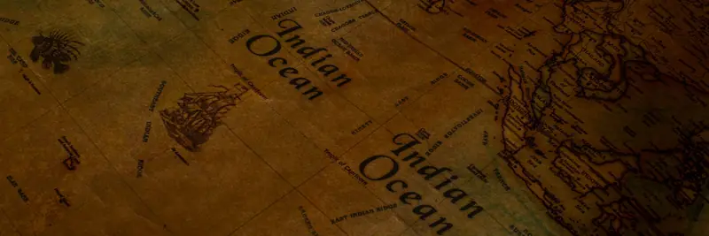 An antique paper map spread out with a compass resting on it